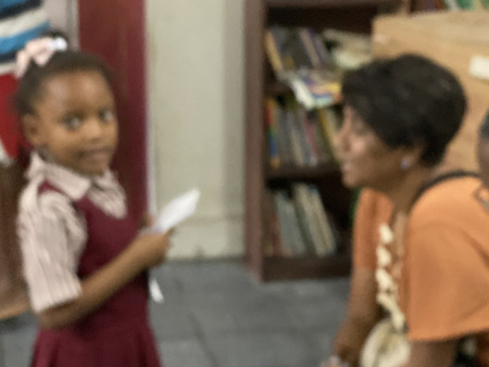 Dr. Malini Saba interacting with a little girl at a Boys and Girls club in Belize